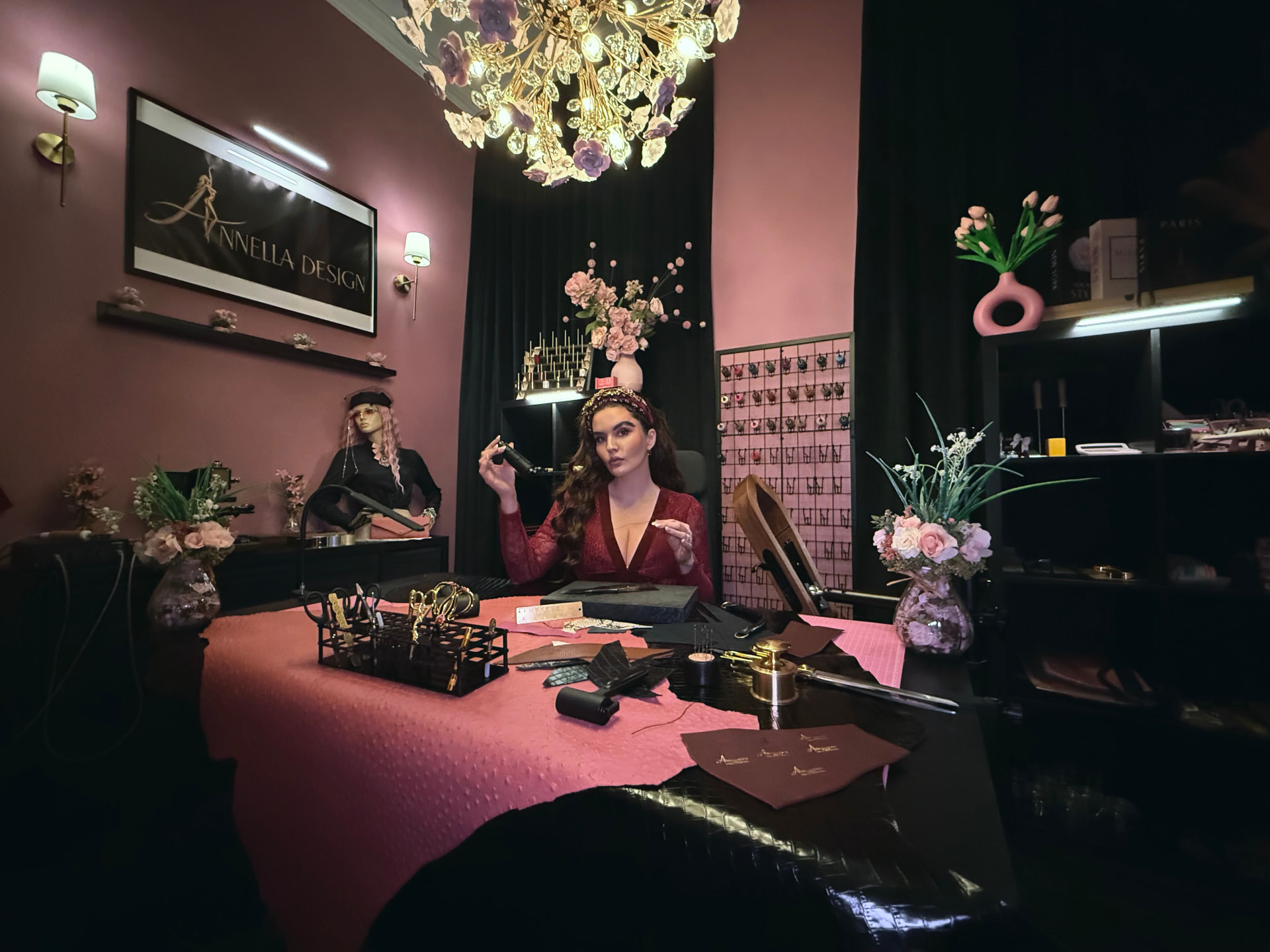 Annella in the Annella Design atelier beneath a gold chandelier