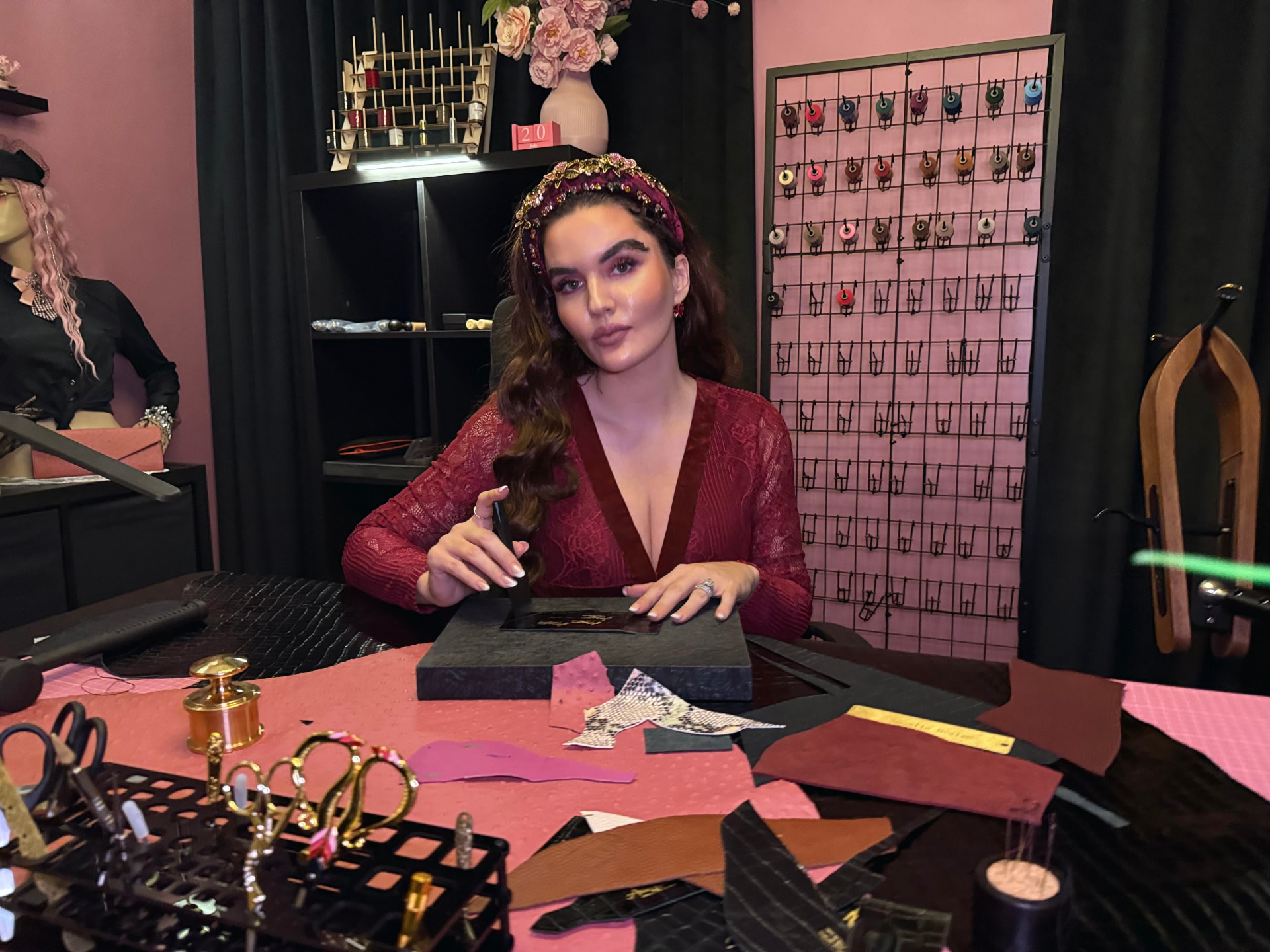 Annella seated at the atelier worktable with leather and tools